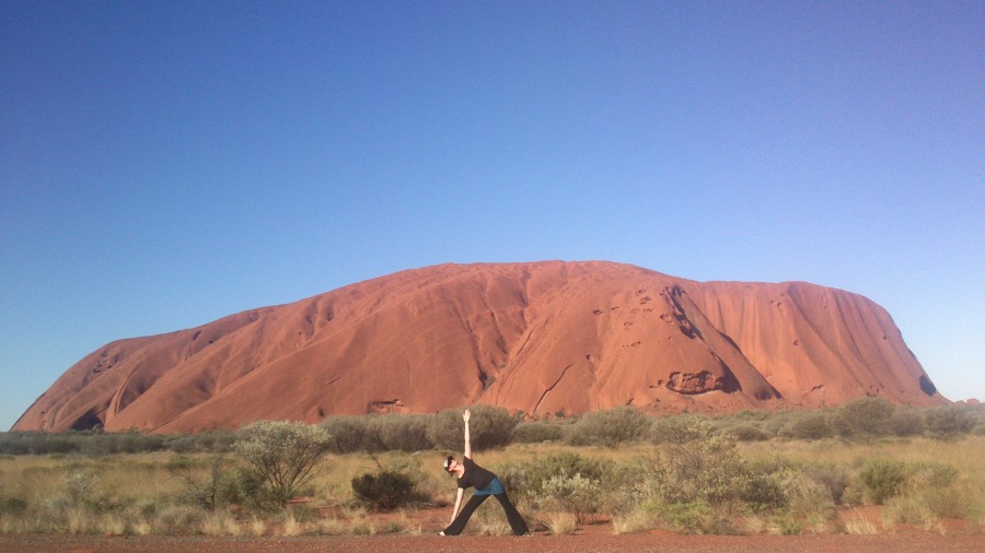 Brooke practices Utthita Trikonasana at Uluru, Northern Territory, Australia