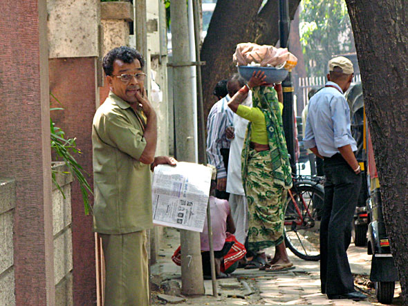 This woman stopped in front of the bank to sell her bananas and vegetables.